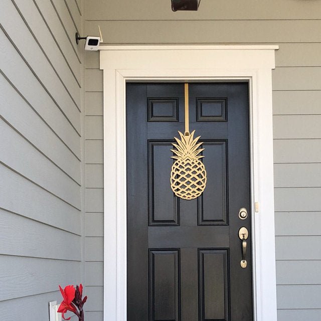 Gold personalized pineapple metal door wreath on a black front door