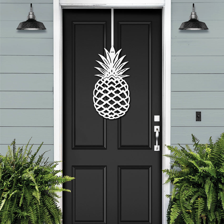 White personalized pineapple metal door wreath on a black front door