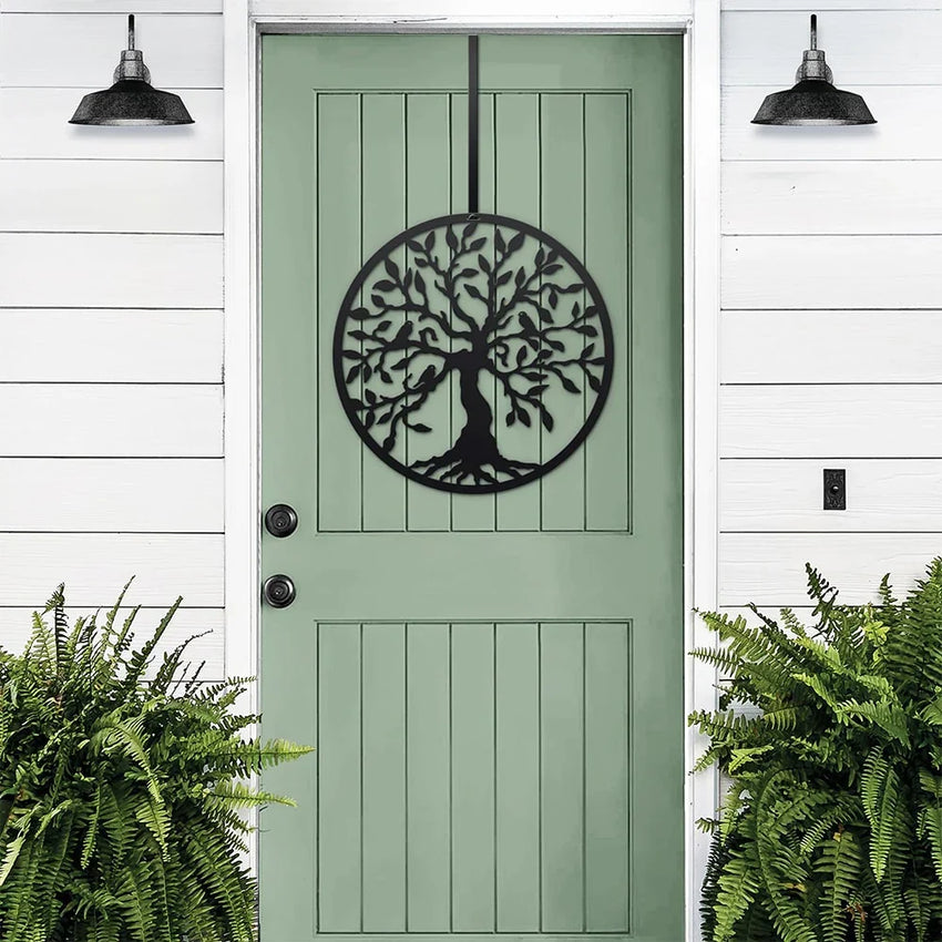 Black Tree of Life metal door wreath displayed on a green front door