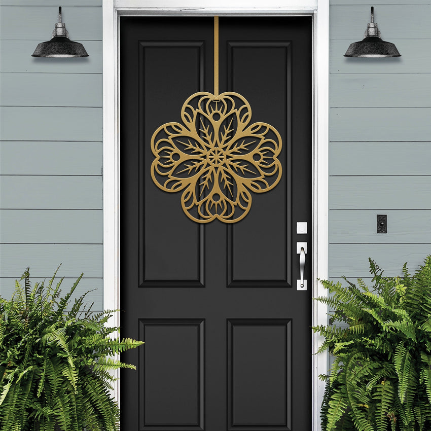 Black front door with gold floral mandala metal door hanger, light blue wall and green plants, custom powder coated farmhouse entry décor, elegant welcome sign design
