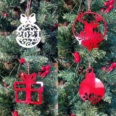 Four Christmas tree ornaments shaped like a ball, deer, gift, and bell hanging on a decorated tree, festive holiday decorations for seasonal home décor