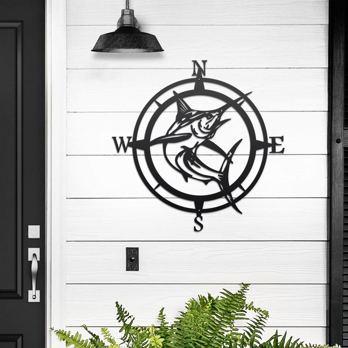 Decorative metal wall art with compass and fish design on white wooden wall, nautical-themed indoor or outdoor décor, custom home wall accent