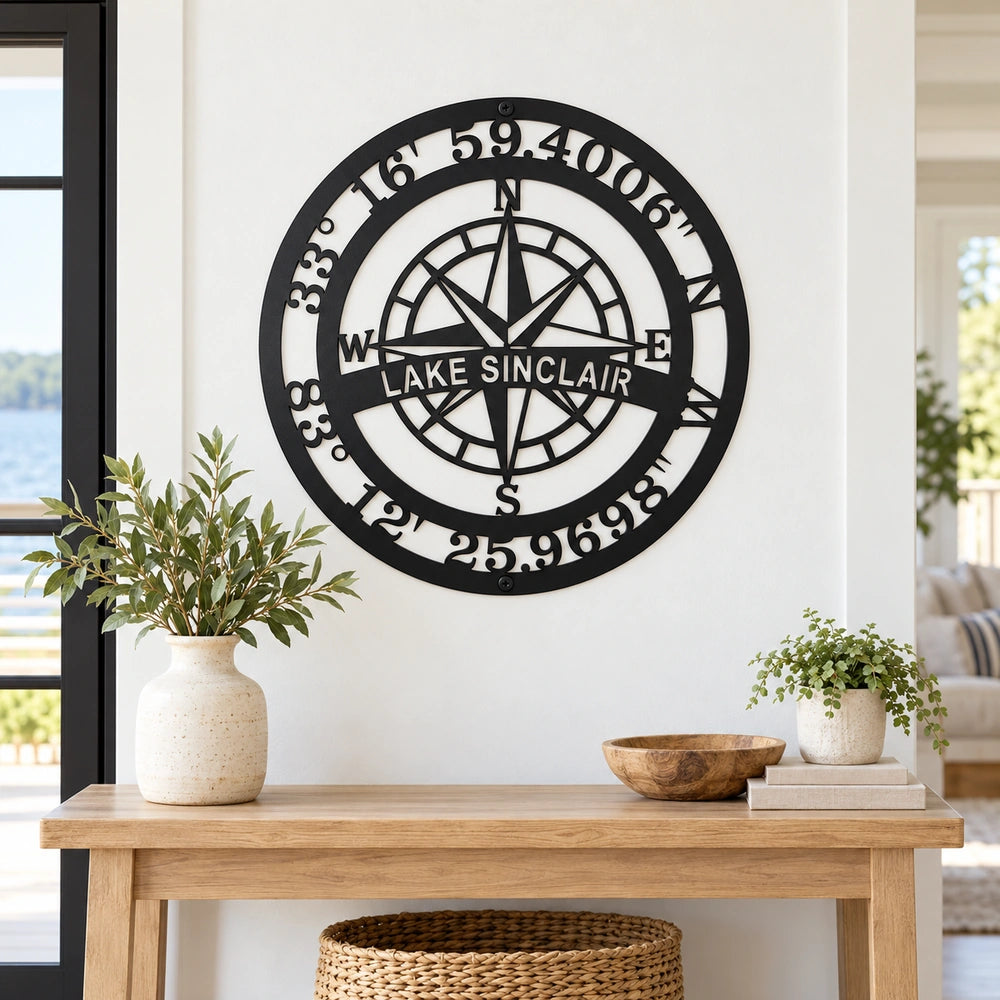 a wooden table with a vase of greenery and a bowl on it, along with a decorative compass wall hanging above.