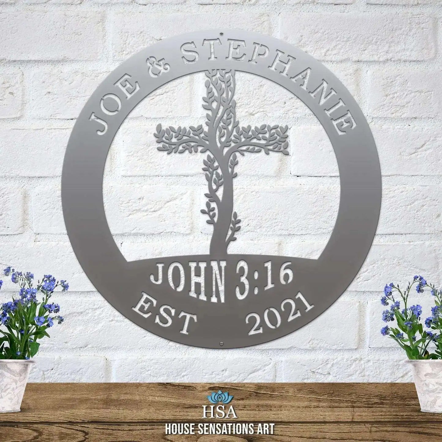 Living Tree Cross with John 3:16 Scripture Established Sign - Personalized Family Name Sign displayed on a table, featuring a metal cross with potted flowers, ideal for home or garden décor.