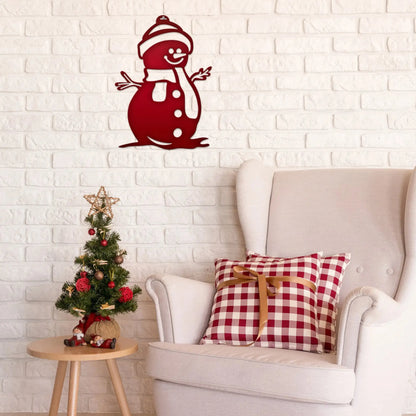 Snowman Door Hanger and Wall Art displayed on a brick wall, accompanied by festive decor including a white chair with a checkered pillow and a small decorated Christmas tree.