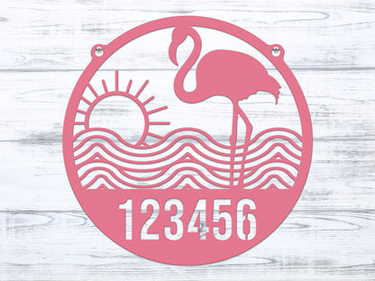 Flamingo Address Sign featuring a pink flamingo, sun, and waves design, crafted from durable metal with customizable house numbers, ideal for home décor and gifting.