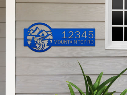 Desert Mountain Monogram Address Plaque displayed on a wall, featuring a custom metal design with mountain and tree motifs, highlighting its role as a stylish, weather-resistant outdoor address sign.