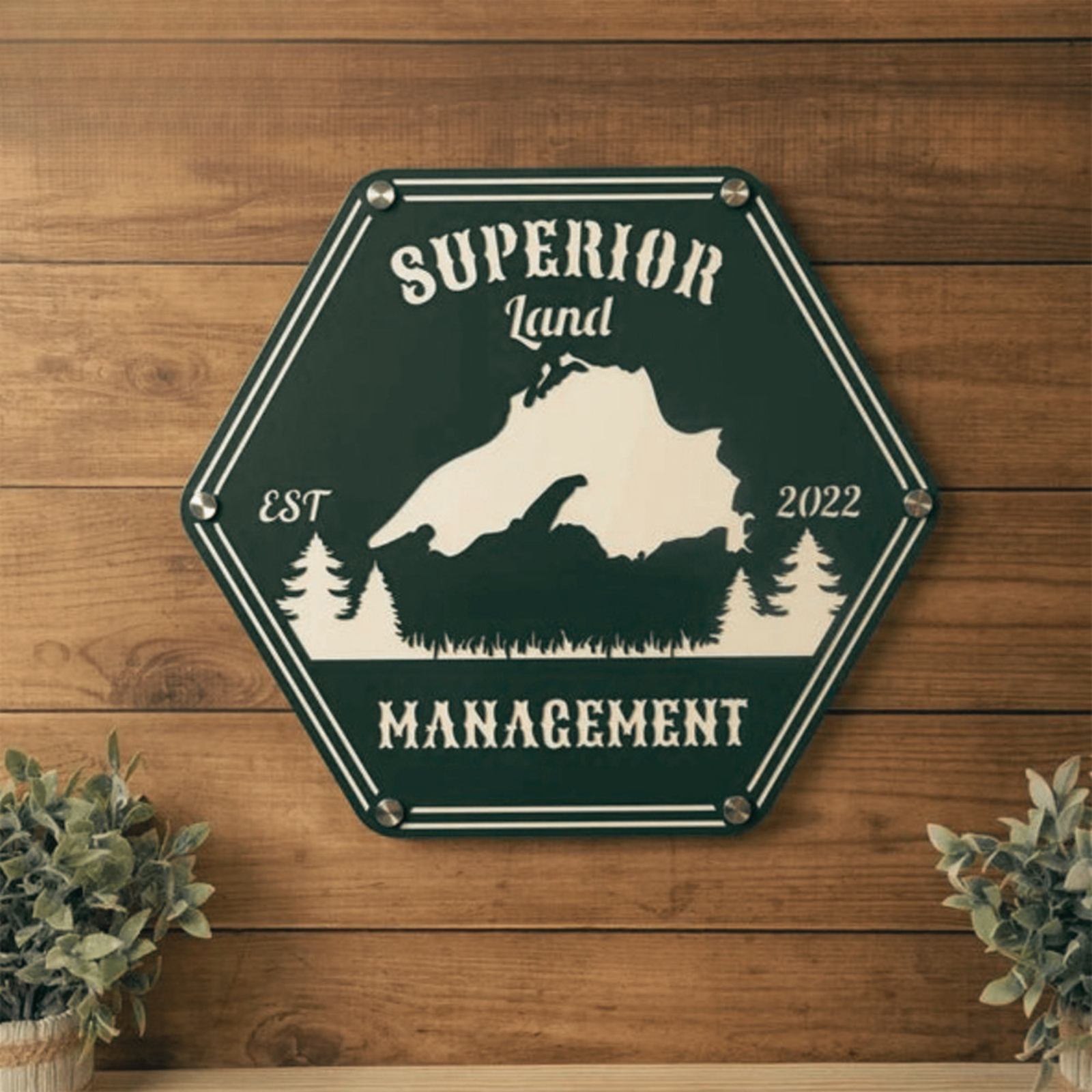 A sign with the text "Superior Land Management" and a silhouette of a mountain, trees, and pine trees.