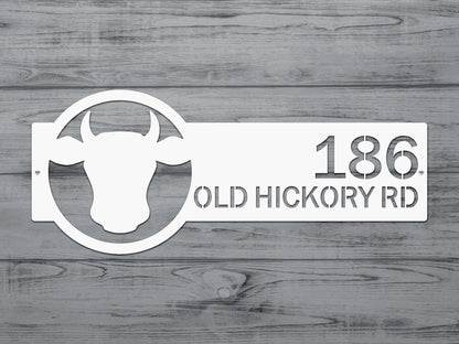 Cattle Farm Monogram Address Sign showcasing a cow head design with numbers, crafted from durable steel. Ideal for outdoor decor, personalizable with street numbers, reflecting rustic farmhouse charm.