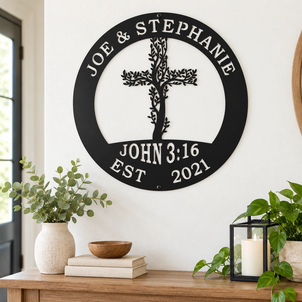 a wall decoration with a tree-like design and a cross, mounted on a wall above a wooden table with various items on it, including a bowl, a candle, and some books.