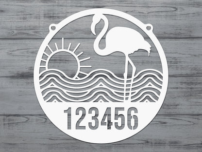 Flamingo Address Sign displaying a white cutout flamingo, sun, waves, and customizable house numbers, crafted from durable metal for outdoor use, perfect for enhancing home décor and gifting.