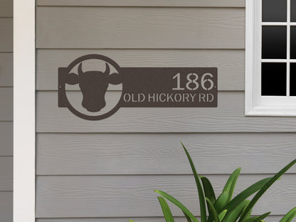 Cattle Farm Monogram Address Sign featuring a laser-cut metal cow head design, perfect for outdoor home décor. Customizable with street numbers, enhancing farmhouse charm and durability. Ideal for housewarming gifts.