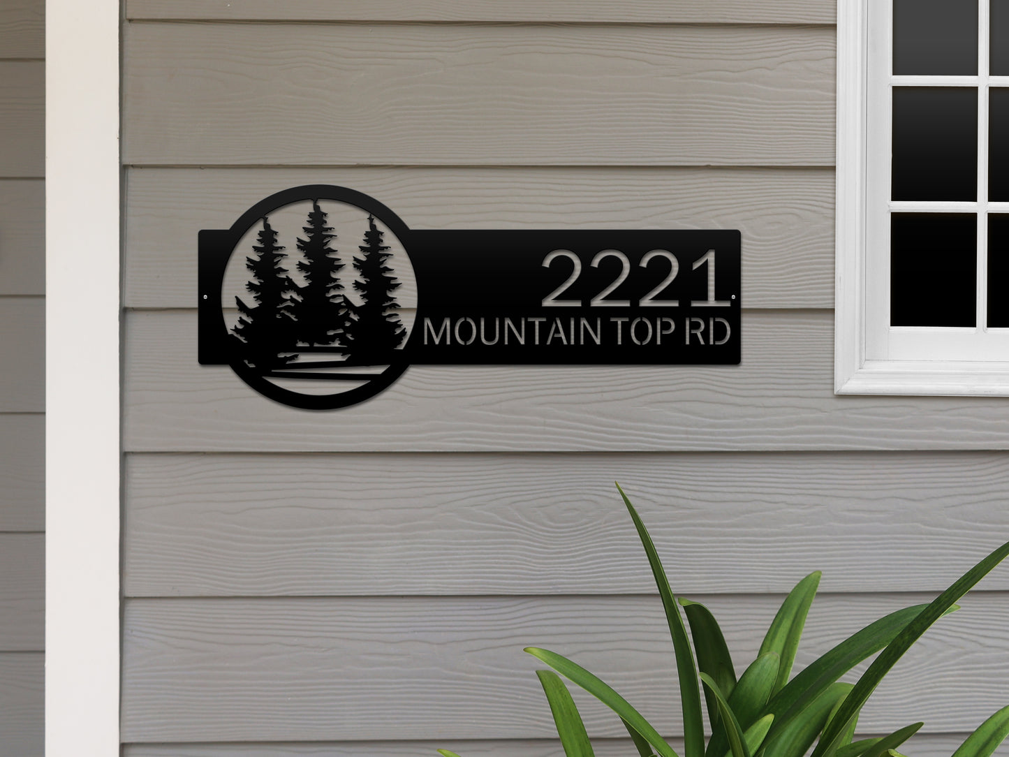 Evergreen Pine Trees Address Sign featuring laser-cut metal design with customizable house numbers and text, mounted on a wall, highlighting its durability and intricate craftsmanship for home décor.