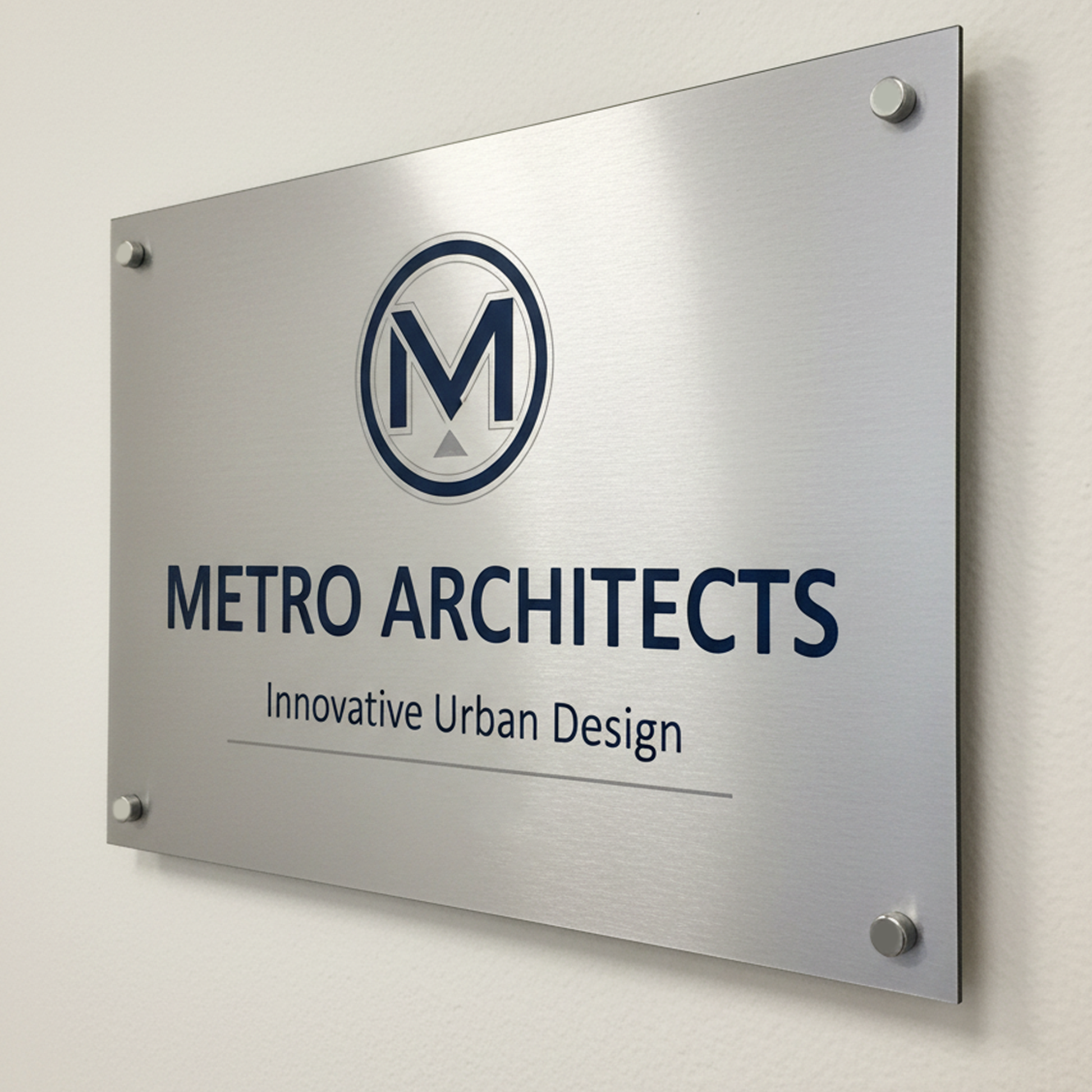 Metal sign with Metro Architects logo and text mounted on white wall, custom laser-cut design for business branding and office décor