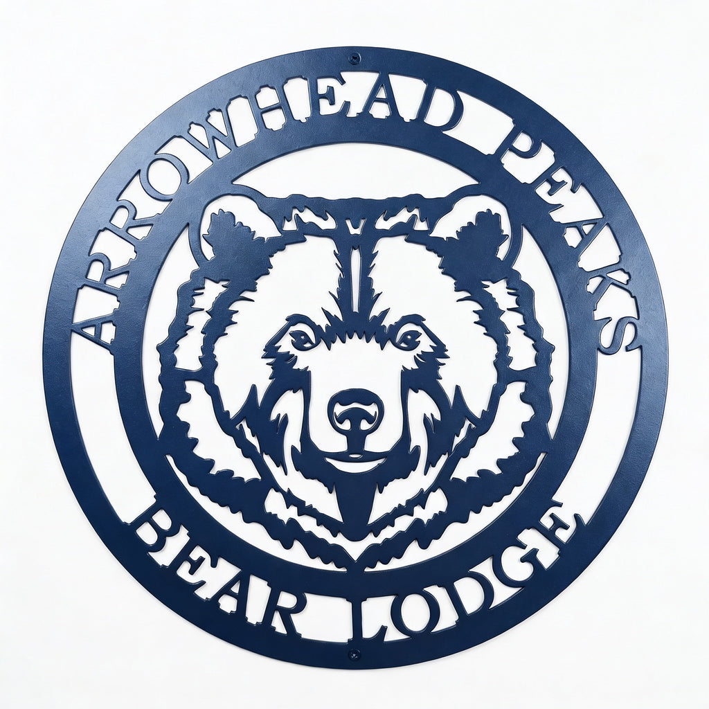 Custom Arrowhead Peaks Bear Lodge metal sign mounted above wooden shelf with books and decorative plants on white shiplap wall