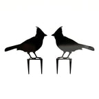 Pair of black cardinal metal garden stakes with mirrored bird silhouettes on a clean white background