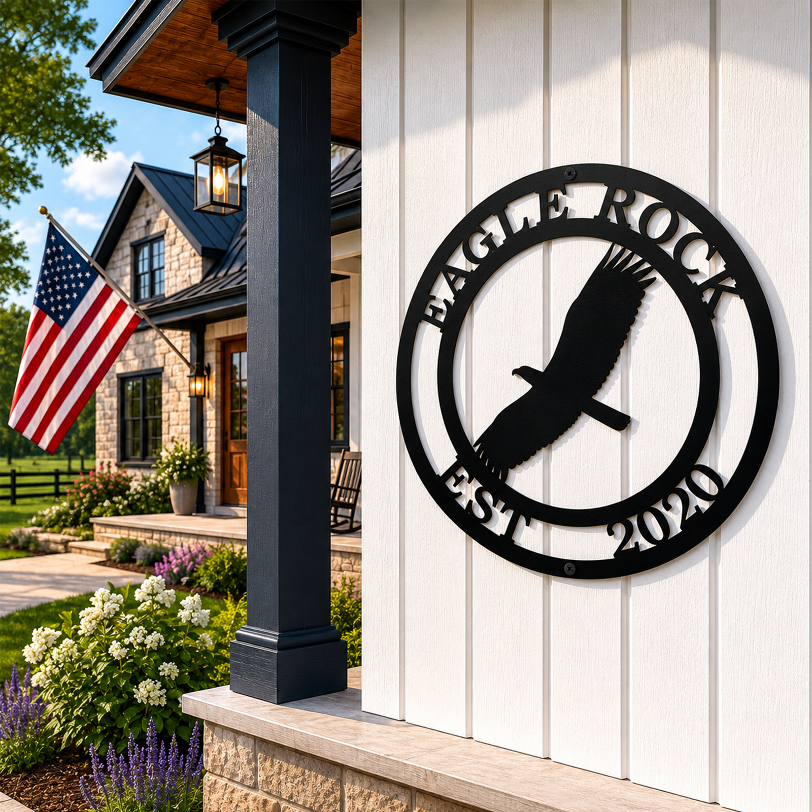 Black personalized Eagle Rock metal sign with Est 2020 displayed on a white porch wall with garden and flag decor