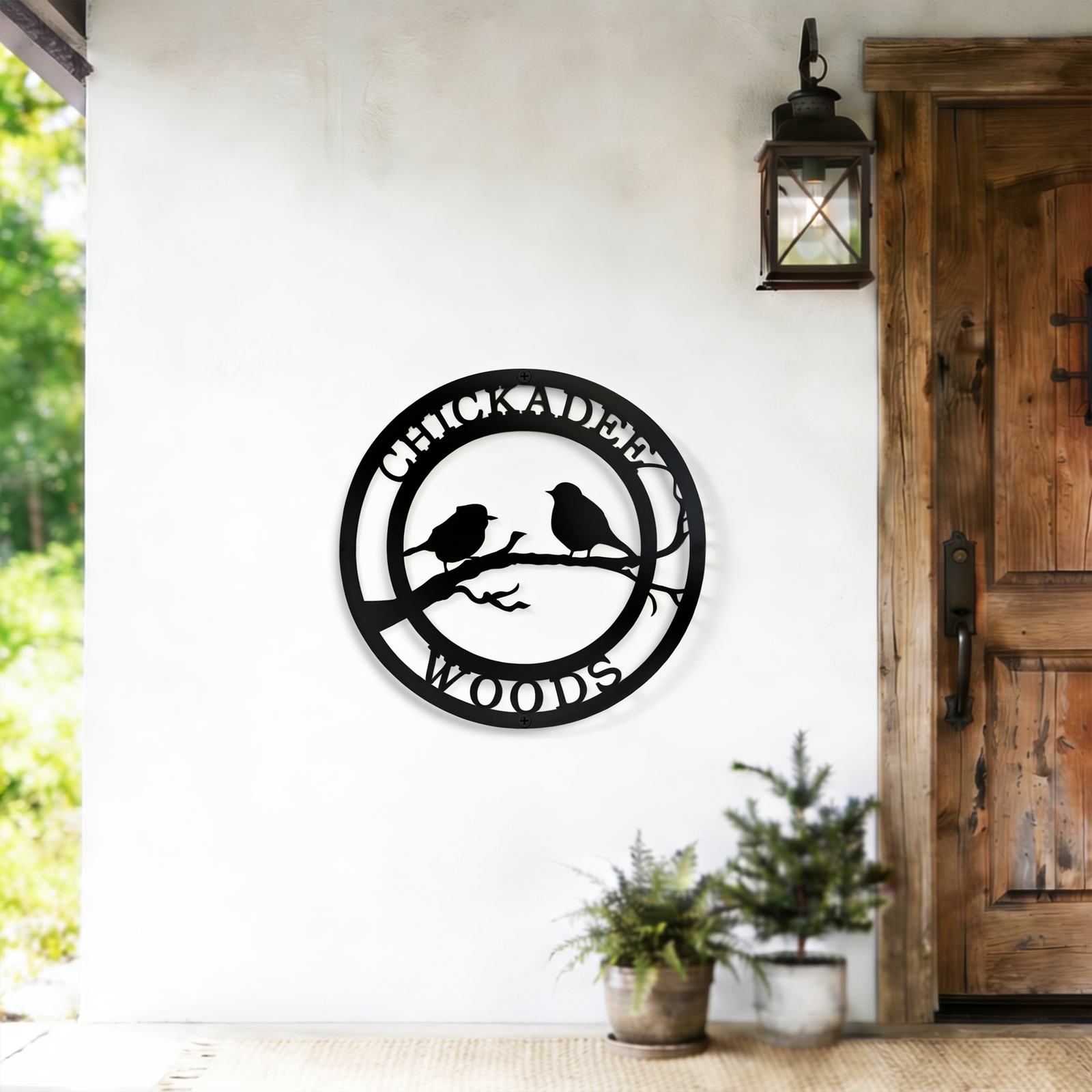 Black chickadee woods metal wall decor displayed beside rustic wooden door