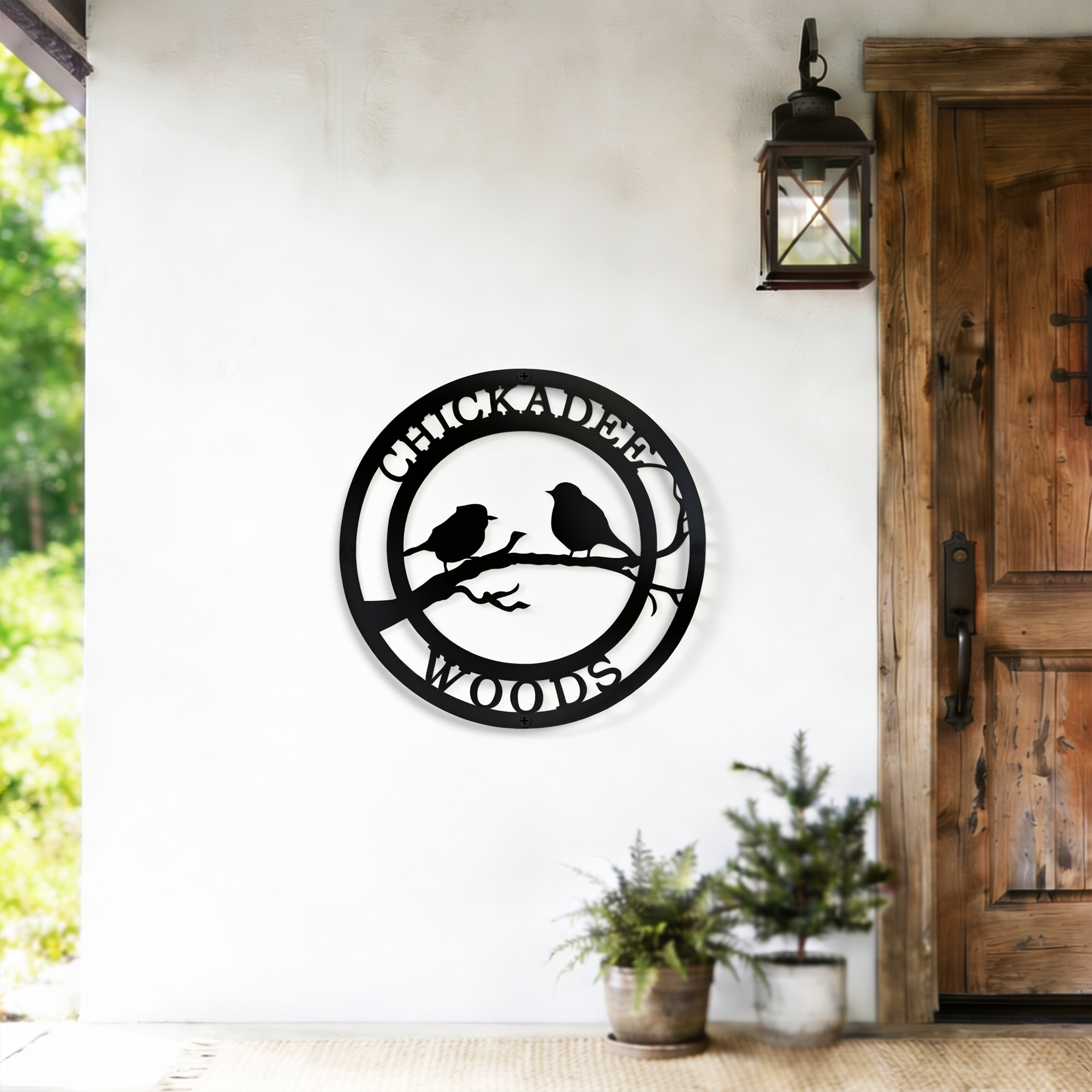Black chickadee woods metal wall decor displayed beside rustic wooden door