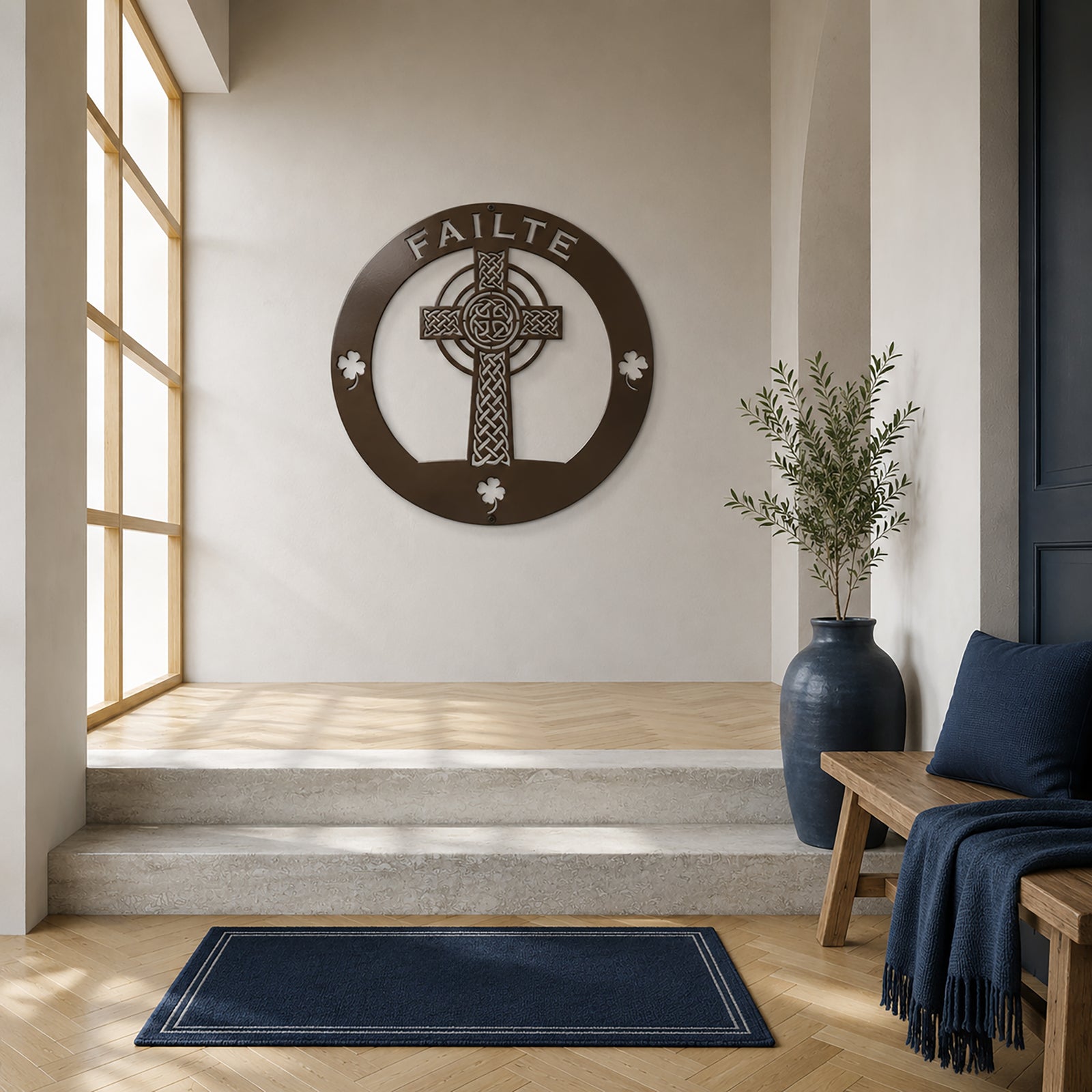 Bronze Celtic cross metal wall decor with Failte text mounted in a minimalist modern entryway interior