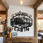 Black cabin mountain metal welcome sign displayed on a white shiplap wall with warm rustic lodge accents