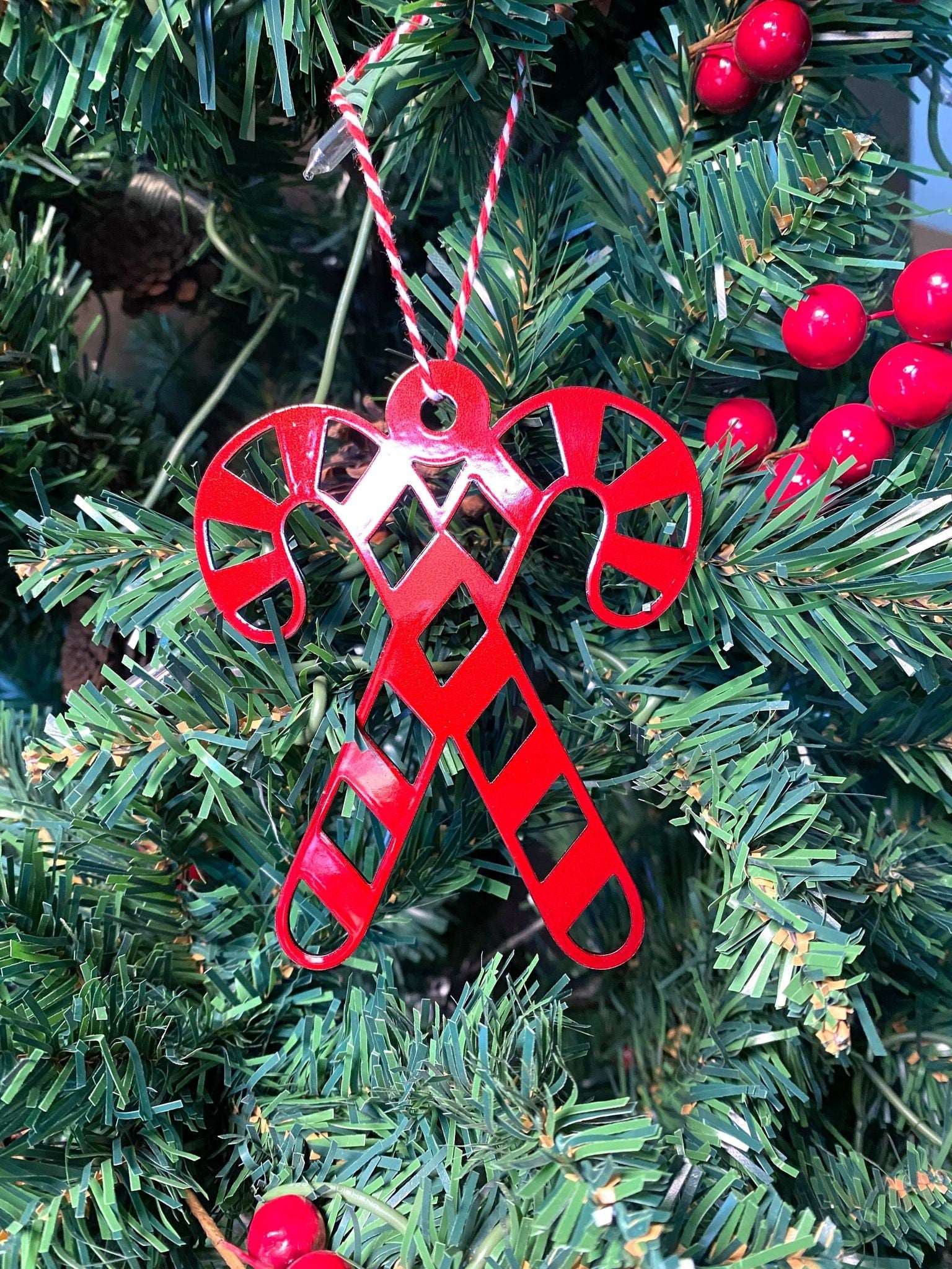 Candy Canes Christmas Ornament - Metal Tree Ornaments feature a red metal candy cane ornament hanging on a Christmas tree, showcasing durable craftsmanship ideal for festive farmhouse décor and gifting.