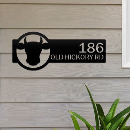 Cattle Farm Monogram Address Sign featuring a black cow head design with custom street numbers, set against a black background, ideal for enhancing farmhouse decor and curb appeal.