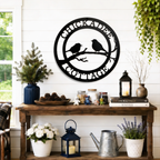 Black chickadee cottage metal wall decor with bird silhouette design displayed above rustic farmhouse entryway table with lanterns and plants