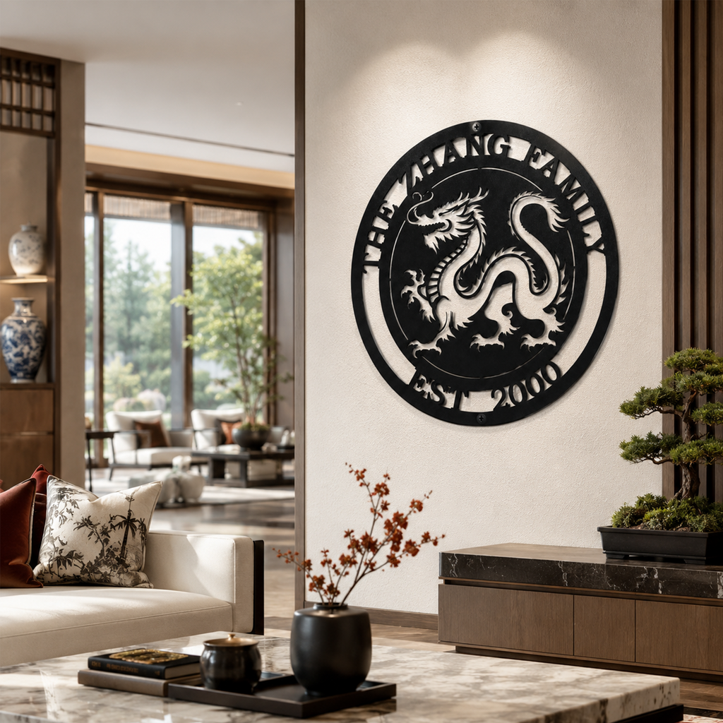 A matte black circular metal sign customized with "THE ZHANG FAMILY EST. 2000" and a traditional dragon silhouette. The piece is styled on a white interior wall panel within a luxury open-concept living area, positioned above a media console styled with a small bonsai tree.
