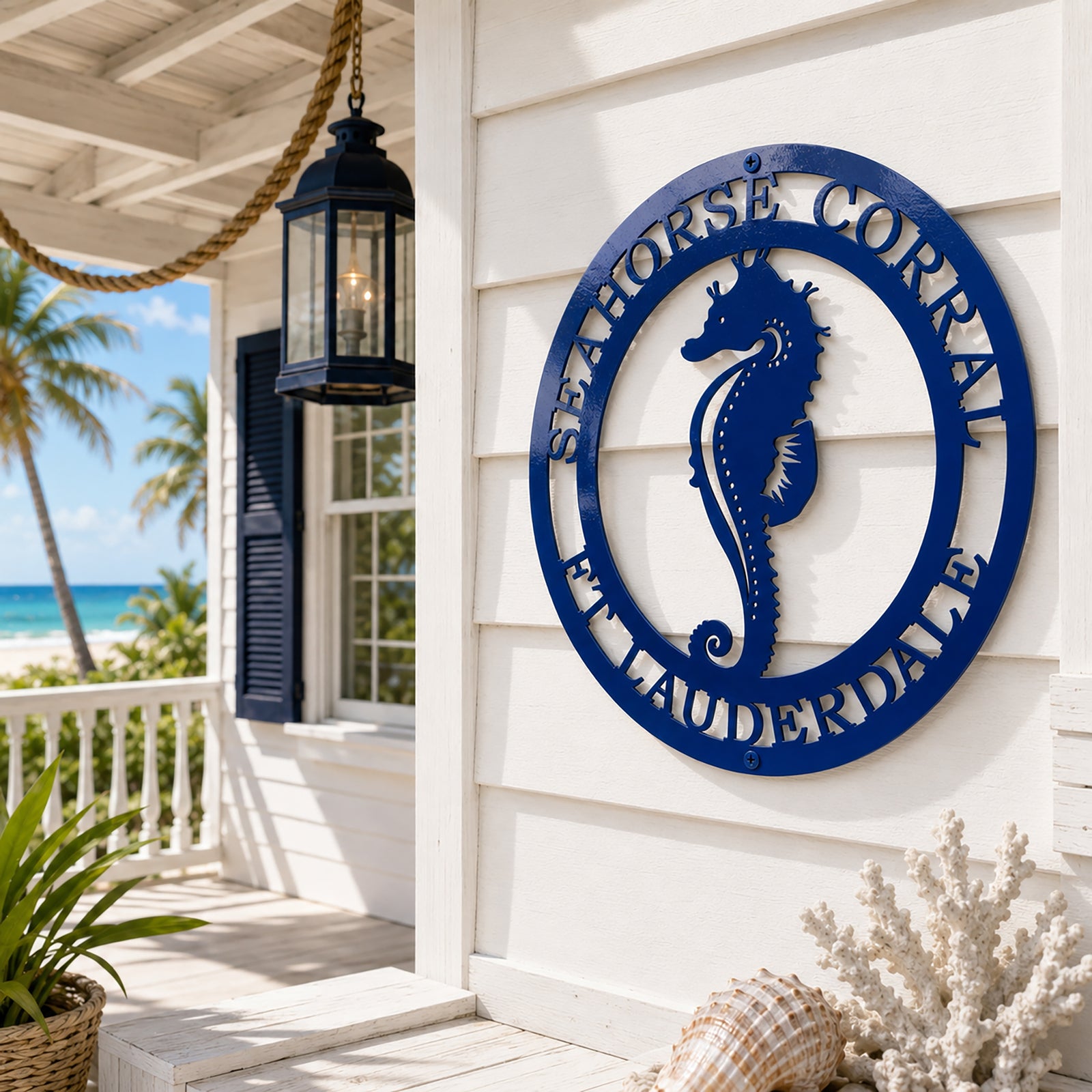 Blue seahorse metal wall art mounted on white porch wall with oceanfront coastal outdoor decor