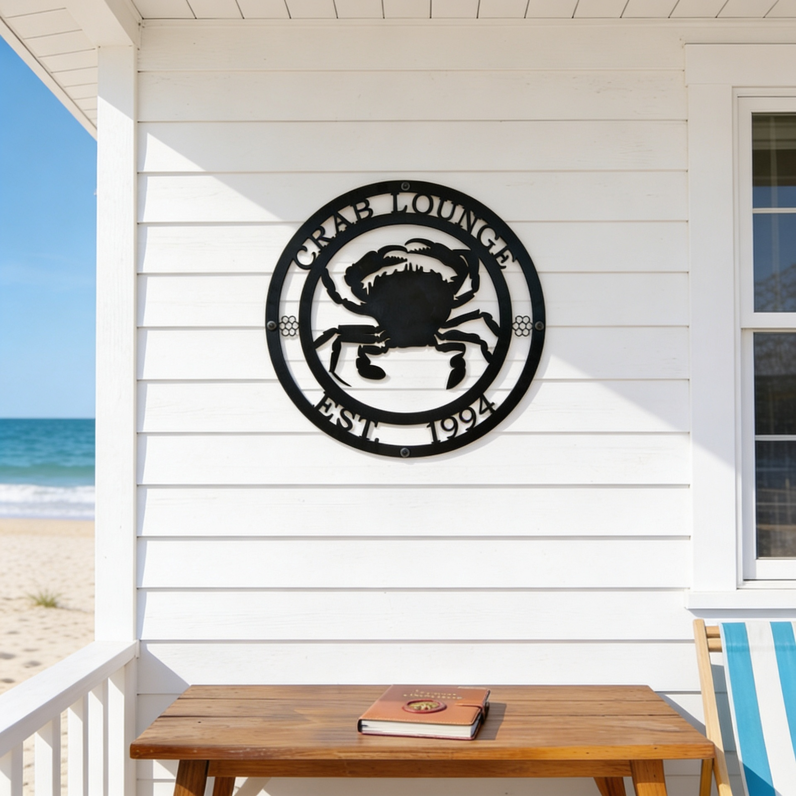 Black crab lounge metal wall sign displayed on beach house porch