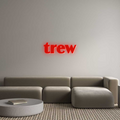 Modern living room featuring a gray sectional sofa and a red neon wall sign, showcasing custom LED décor for contemporary interiors.
