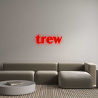 Modern living room featuring a gray sectional sofa and a red neon wall sign, showcasing custom LED décor for contemporary interiors.