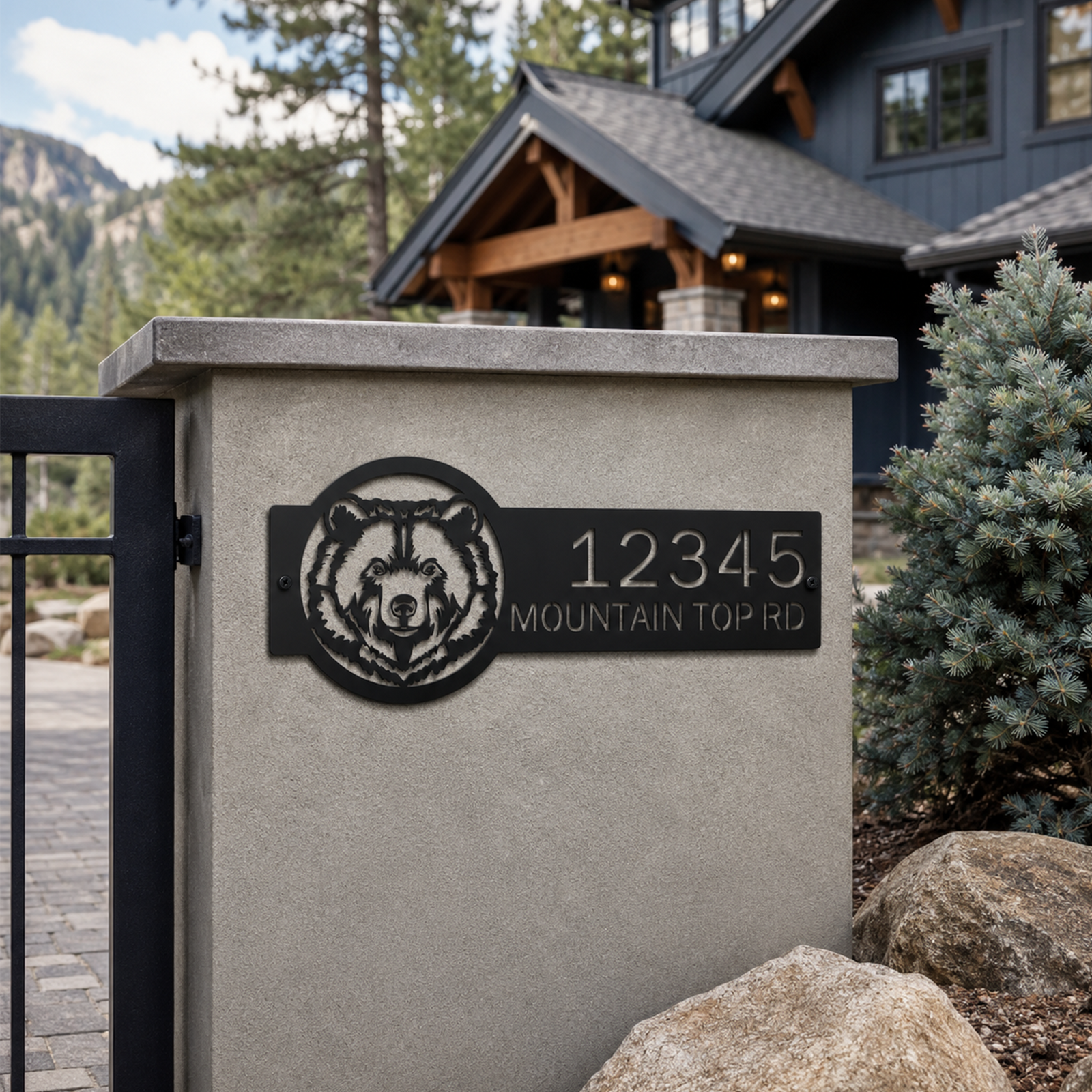 Personalized black bear metal address sign mounted on stone entry pillar outside luxury mountain lodge home