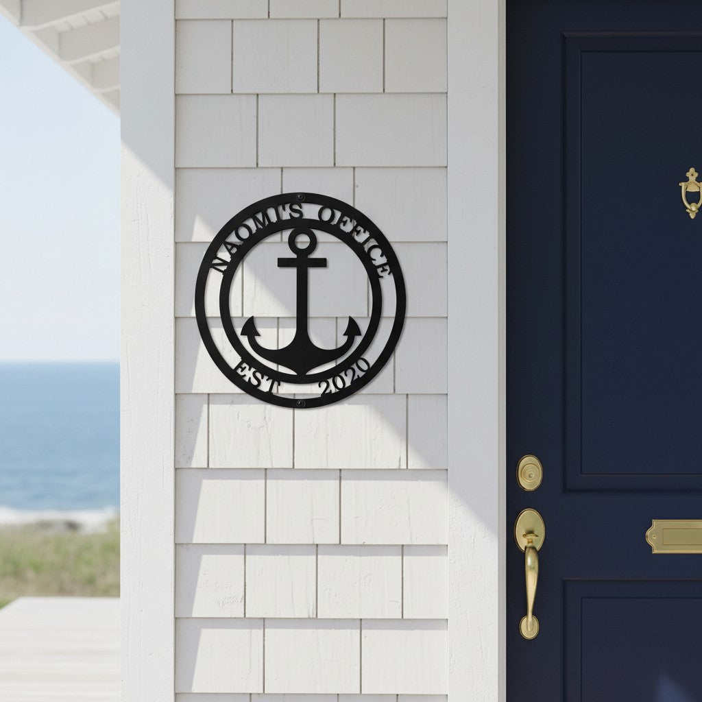 Matte black personalized anchor metal name sign with custom text Naomi's Office Est 2020 mounted on a white shingle exterior wall next to a luxury navy blue front door.