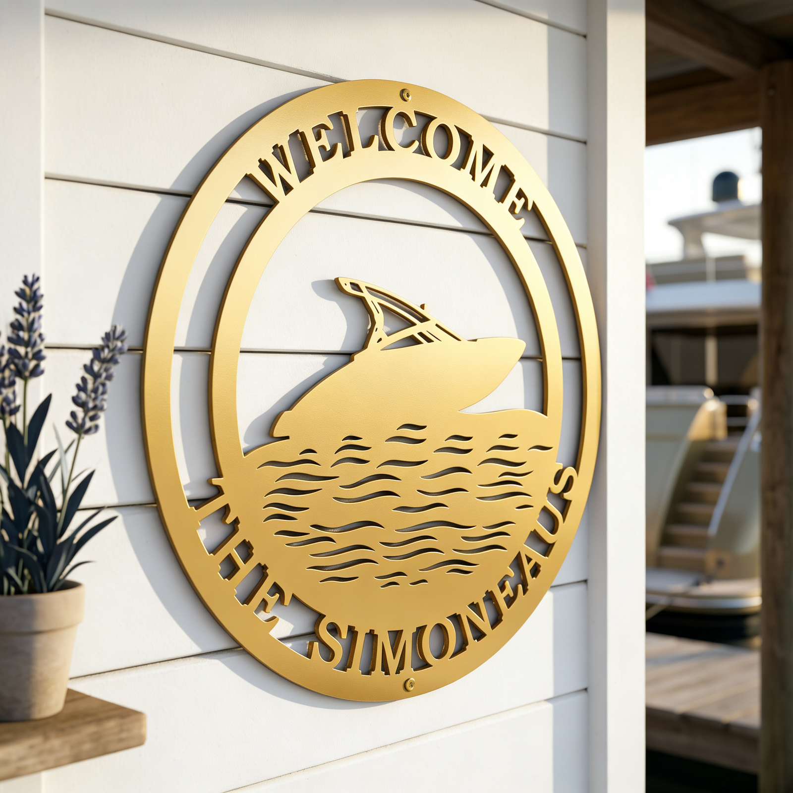 A gold circular metal welcome sign reading "The Simoneaus" and featuring a speedboat cutout, mounted on a clean white shiplap wall next to a potted plant.