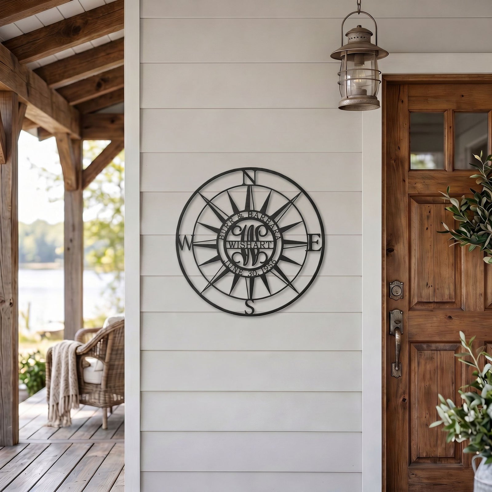 Personalized compass rose metal wall art displayed on modern farmhouse porch beside wooden front door