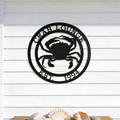 Black crab lounge metal sign with crab design displayed above seashell table decor