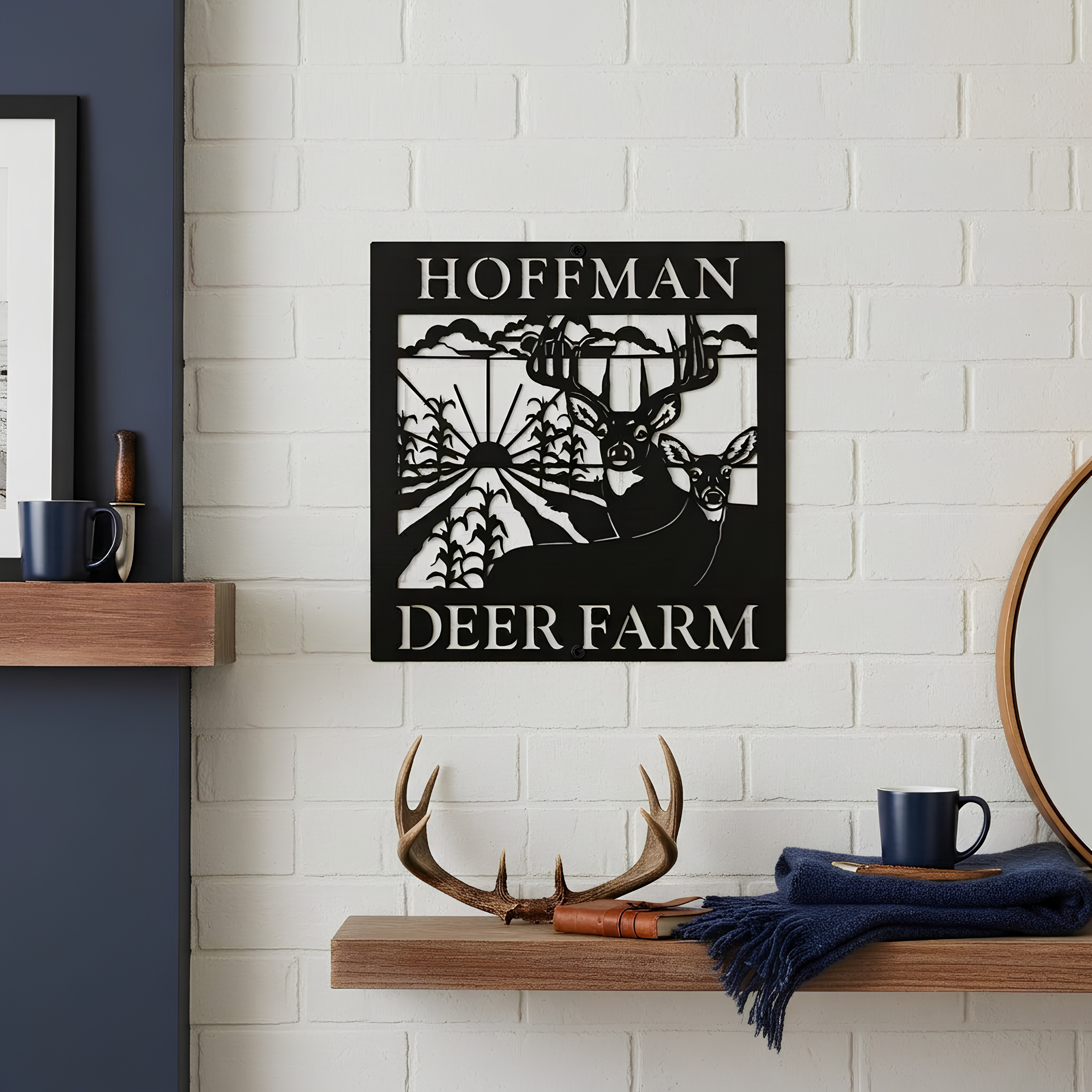 Black personalized metal sign reading “HOFFMAN DEER FARM” displayed on a white brick interior wall above a wooden shelf with antlers and rustic decor.