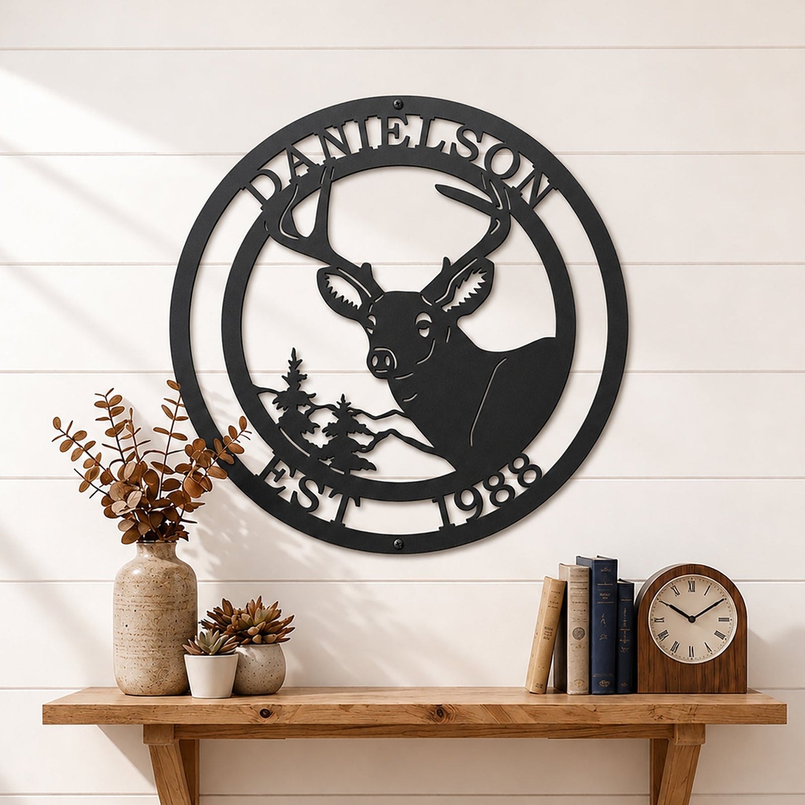 Black deer metal wall sign with personalized surname and EST 1988 displayed on white shiplap wall shelf décor