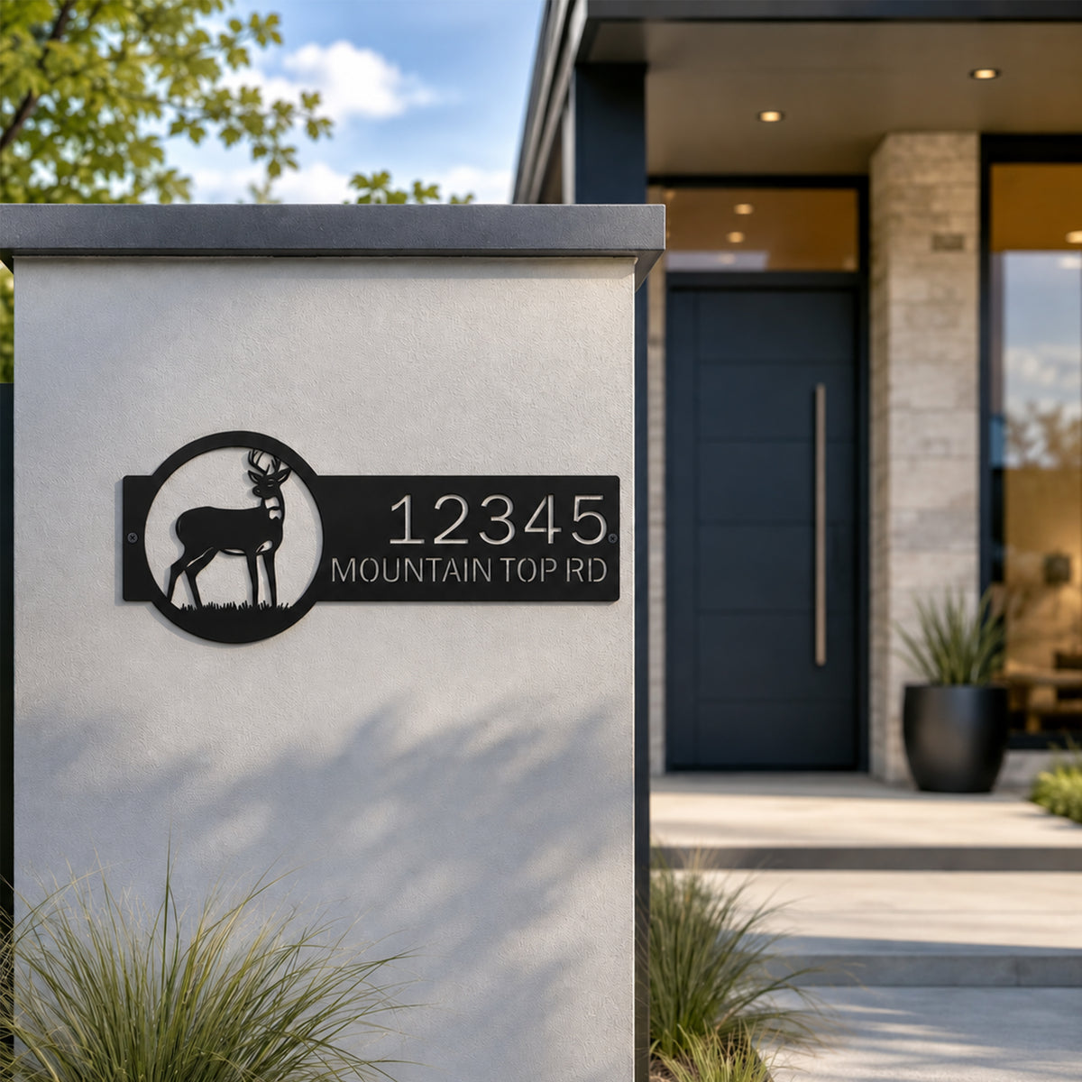 Black outdoor deer address sign mounted on modern concrete pillar featuring custom house number and mountain top road street name metal artwork