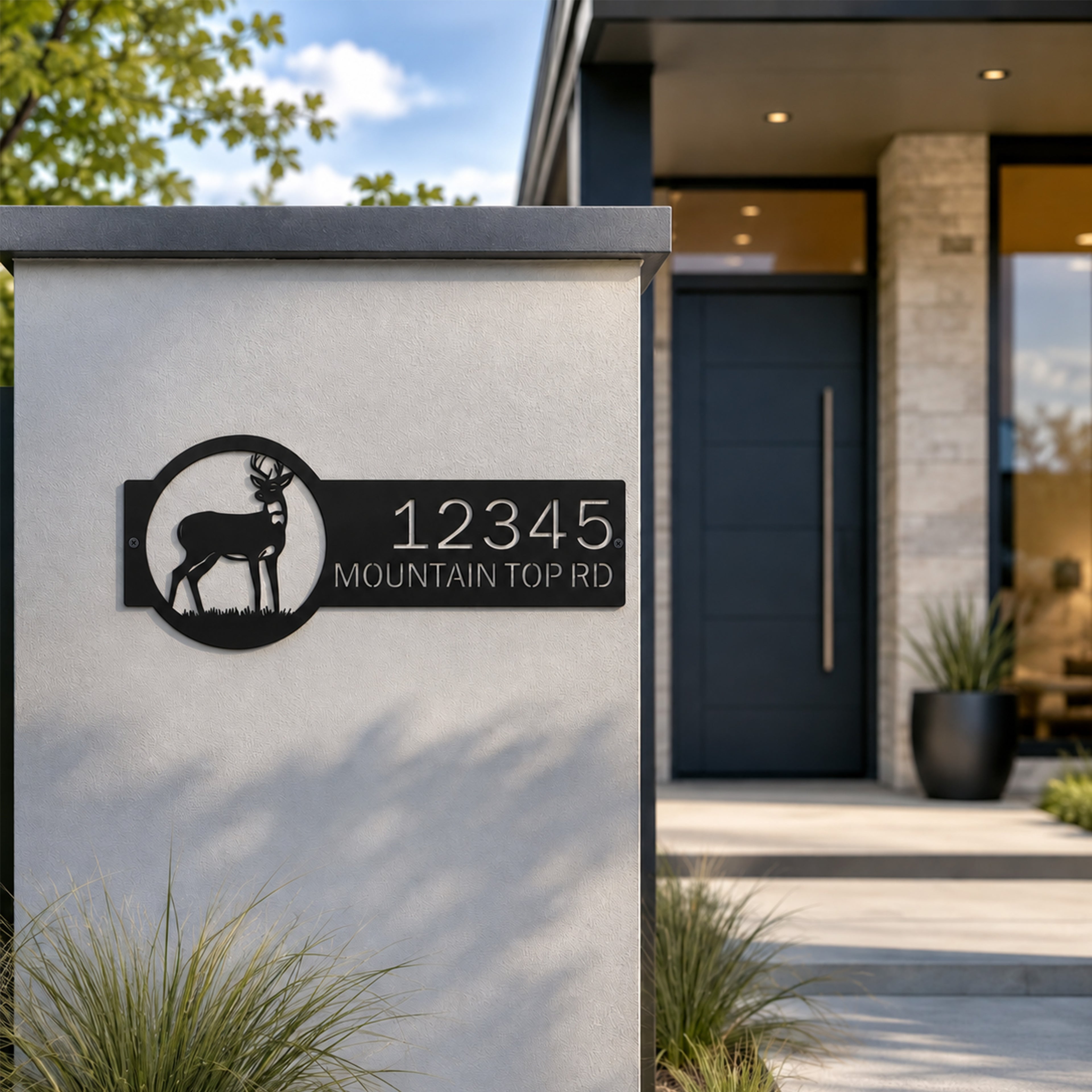 Black outdoor deer address sign mounted on modern concrete pillar featuring custom house number and mountain top road street name metal artwork