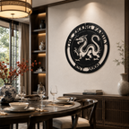 An onyx black circular metal plaque showcasing a majestic dragon cutout design and the text "THE ZHANG FAMILY EST. 2000" on its rim. The sign is mounted on a dining room wall above a dark wooden buffet cabinet, with a round marble table set for a formal dinner visible in the foreground.