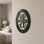 Custom gloss black family monogram metal sign featuring a personalized surname, children’s names, and established date mounted on an interior wall.