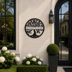 Personalized black tree monogram metal sign with custom family name displayed beside elegant outdoor entryway and garden plants