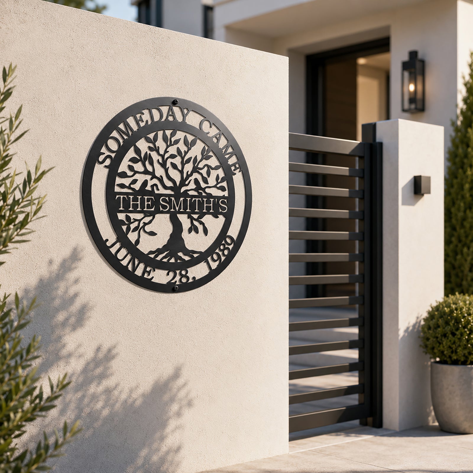 Custom family tree metal sign — personalized satin black family name sign mounted on a modern exterior entry wall near a contemporary gate.