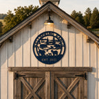 Round navy blue ranch metal wall art mounted above rustic barn doors with personalized ranch name and established year