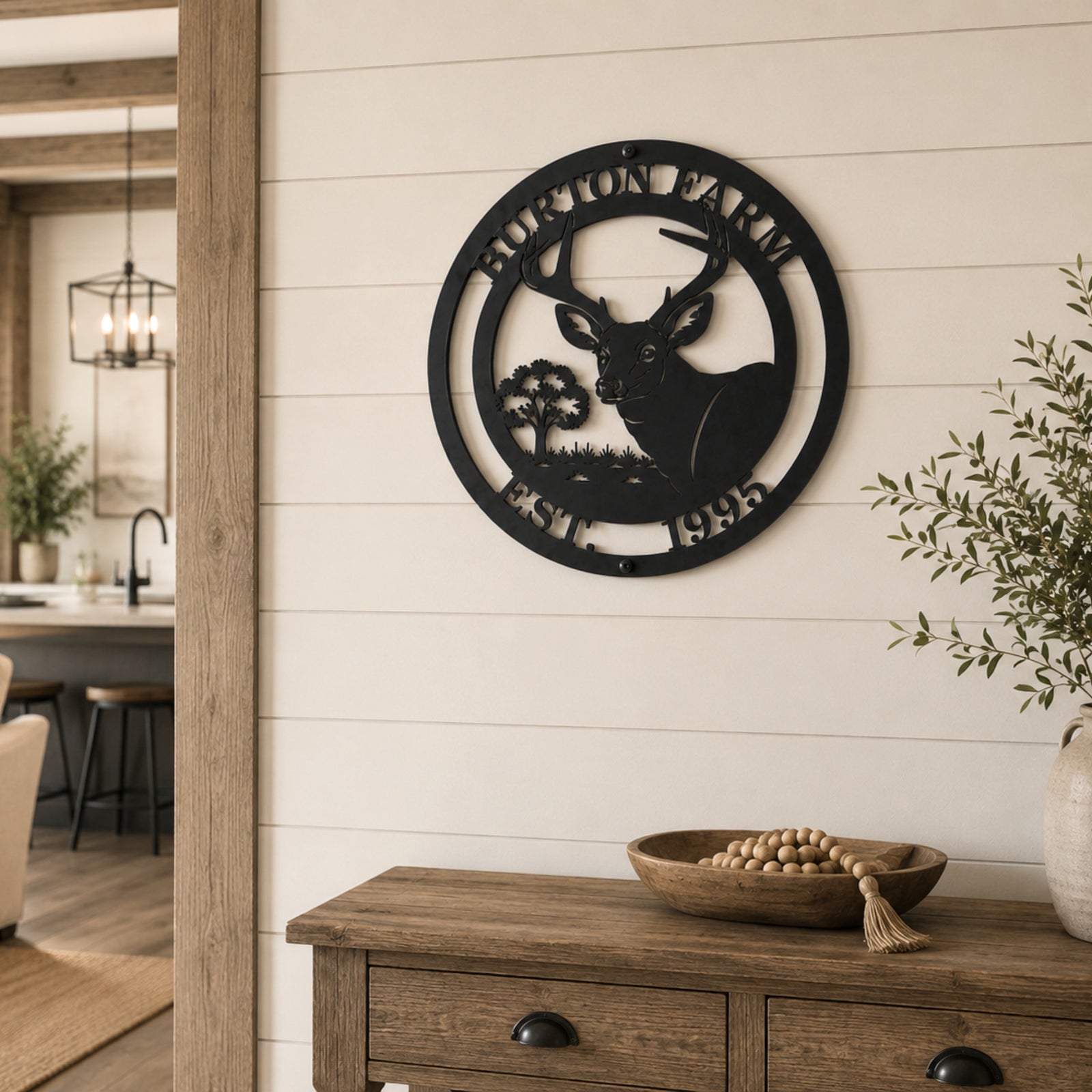 Black deer silhouette metal wall sign with custom farm name mounted above rustic farmhouse console table