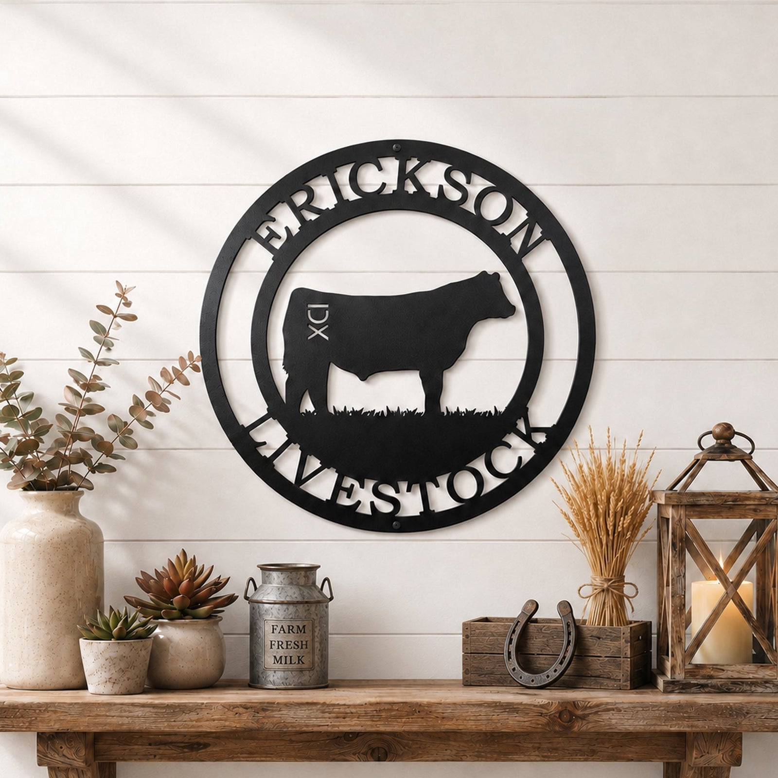 Black livestock metal wall sign with cattle silhouette and custom farm name displayed above rustic farmhouse shelf décor