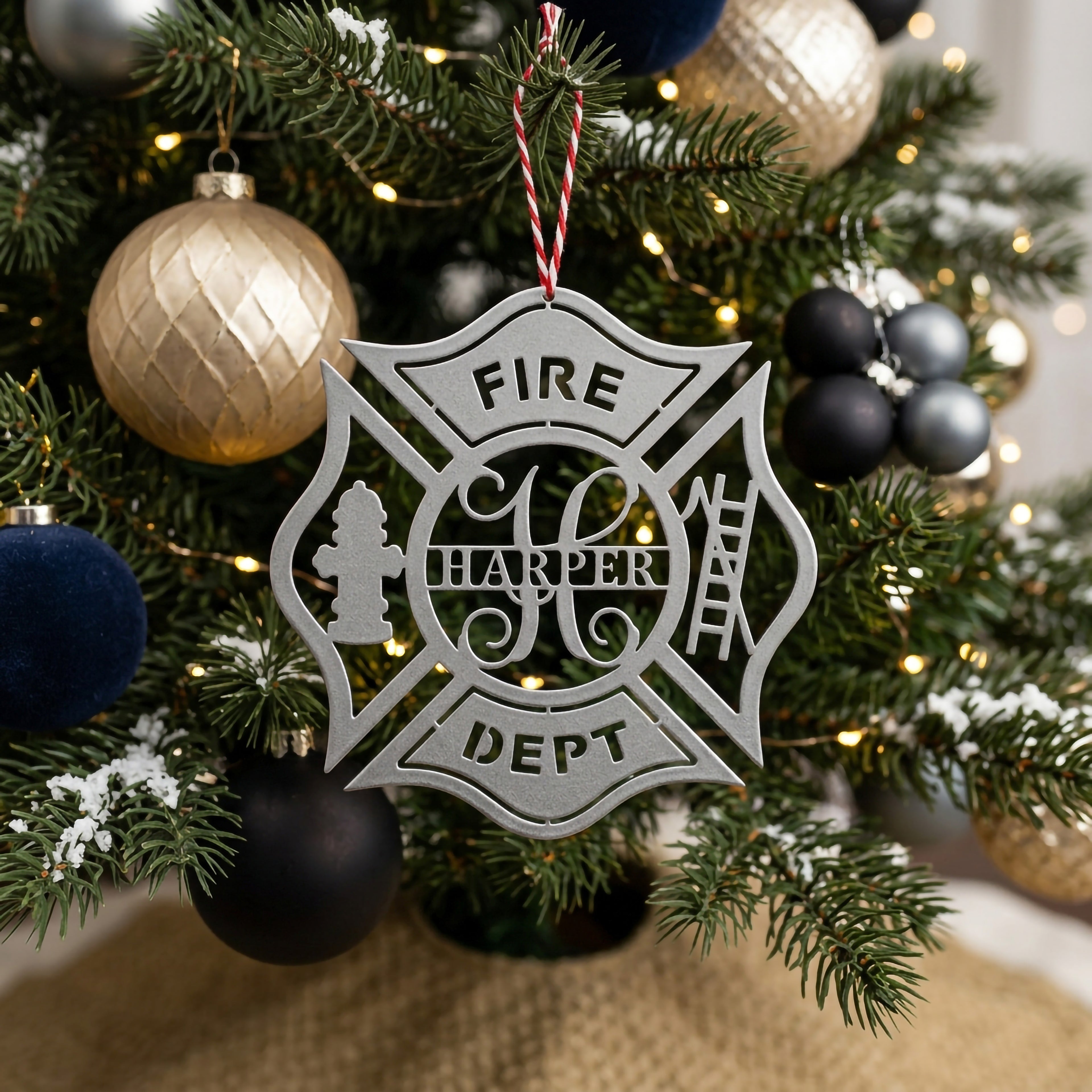 Personalized firefighter Christmas ornament with fire hydrant and ladder details displayed on festive Christmas tree with warm lights